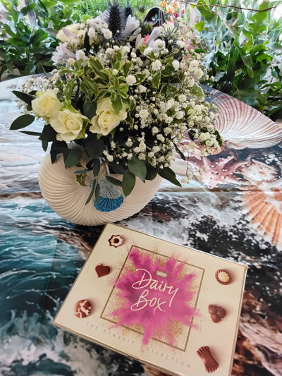 Stanley sunflowers seashell vase - A small seasonal mix of blue and white flowers arranged in a seashell vase alongside free chocolates